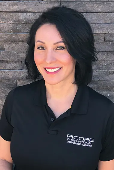Smiling Picore International compliance manager in a black uniform with professional security expertise.